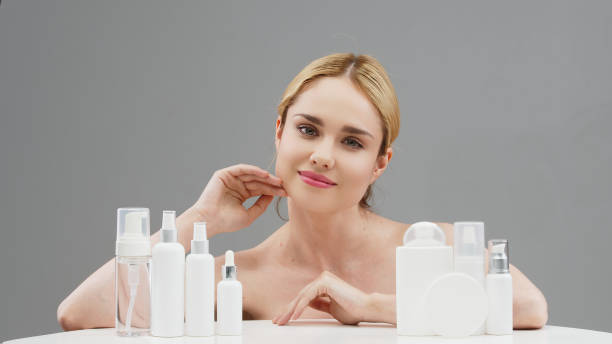 A woman with various skincare and cosmetic products, highlighting the importance of skin expertise for foundation.